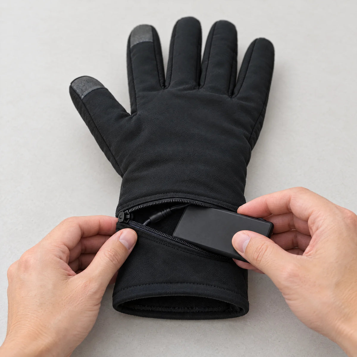 Battery slides into the zippered pocket on the wrist