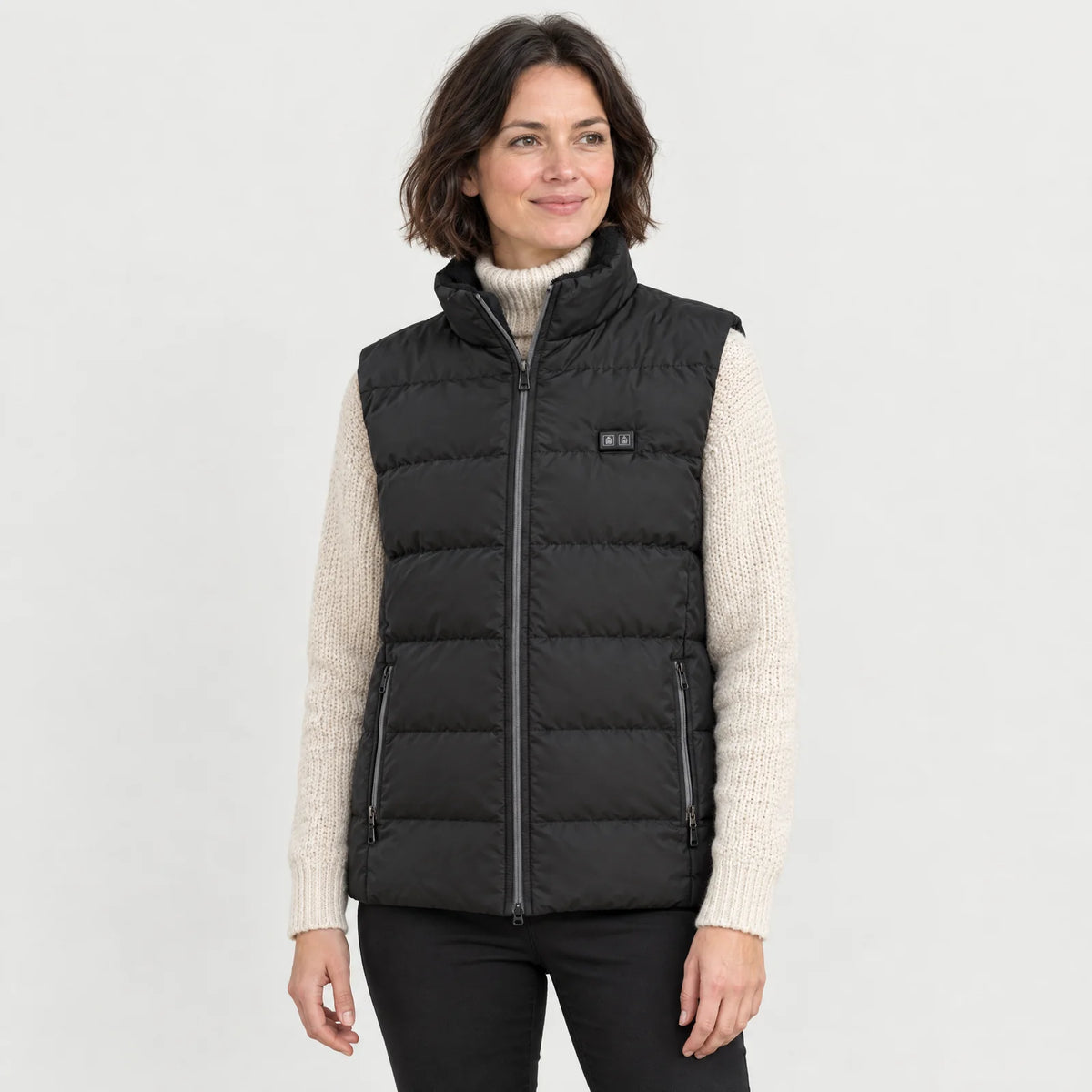 Woman wearing the heated vest 2.0 over a cream turtleneck